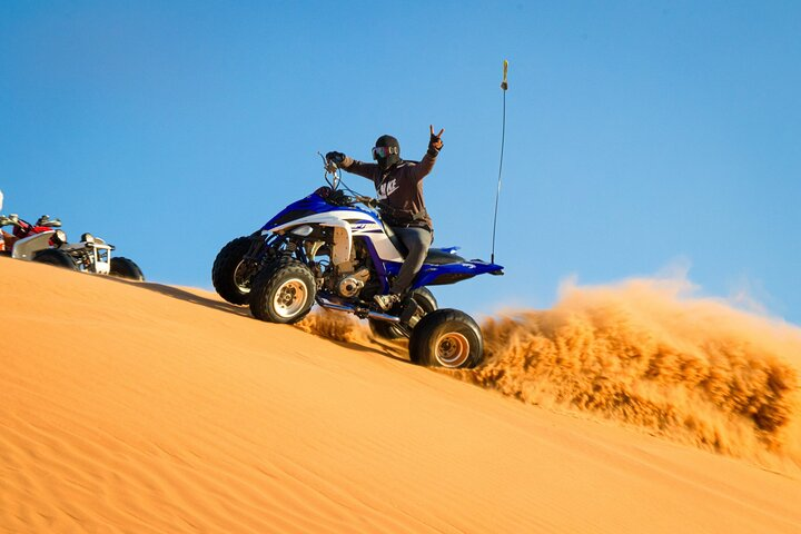 Roaring through golden sands on an ATV riders embrace the excitement of conquering desert dunes. The stunning landscape and exhilarating ride create unforgettable outdoor adventures in Dubai's vast wilderness.